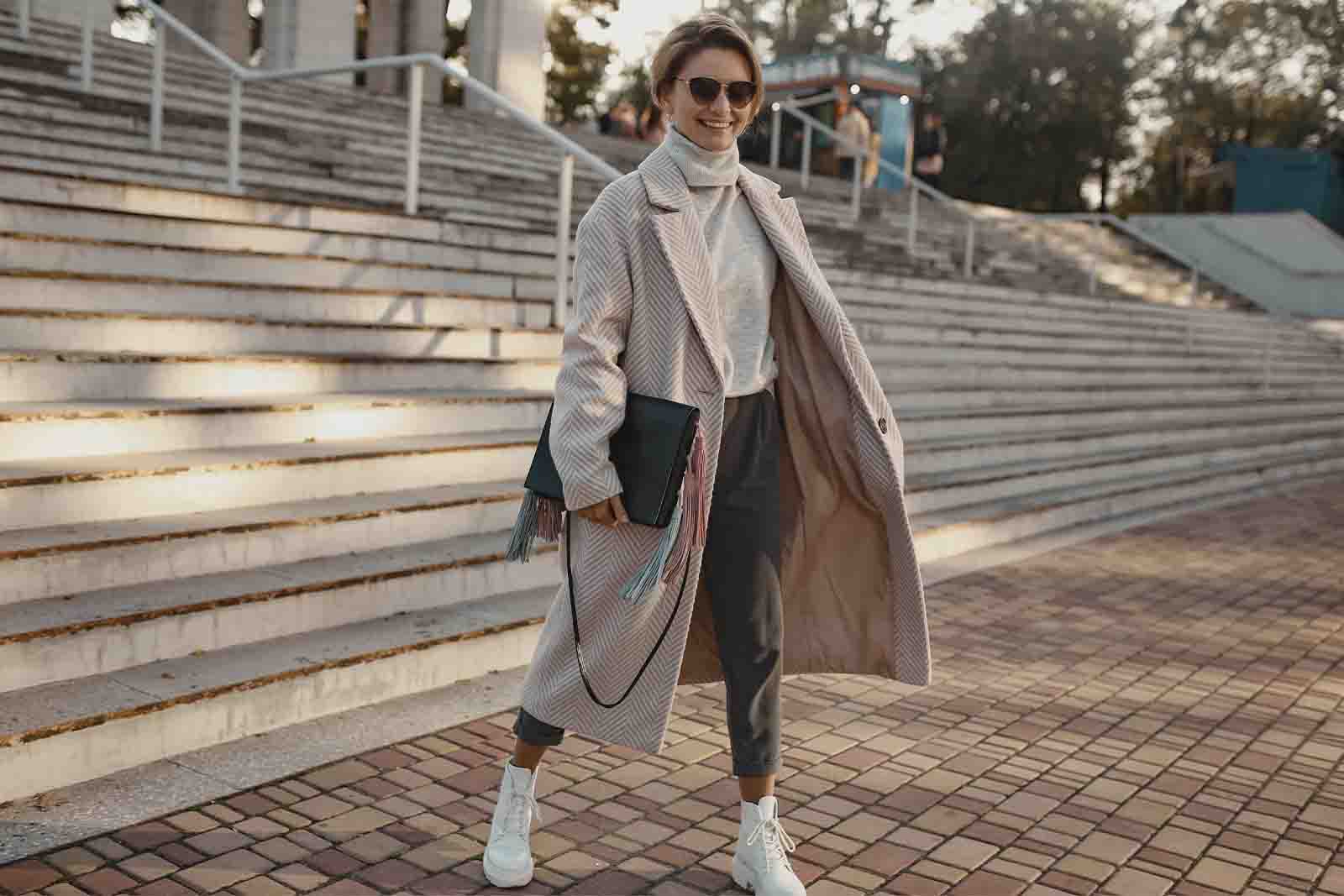 Imagem de uma modelo com roupas de frio bege e tenis cano alto branco 