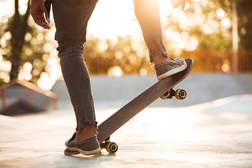 Skatista equilibrando-se em um skate ao amanhecer