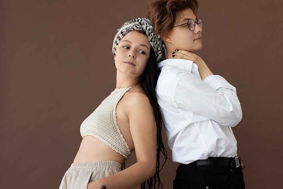 Duas mulheres posando de costas em fundo marrom