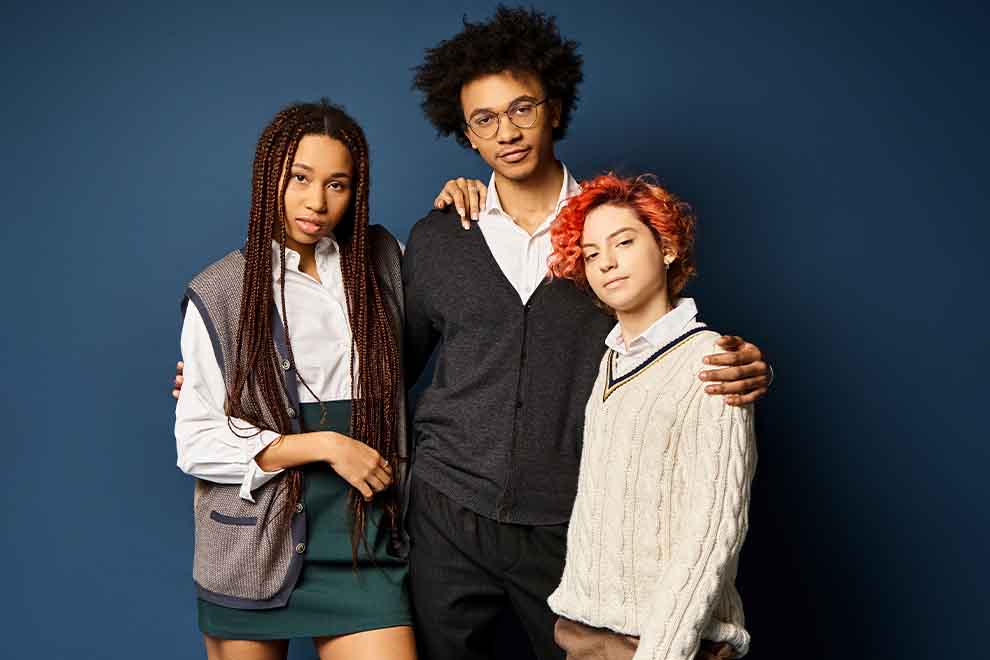 Três jovens posando juntos com roupas estilosas